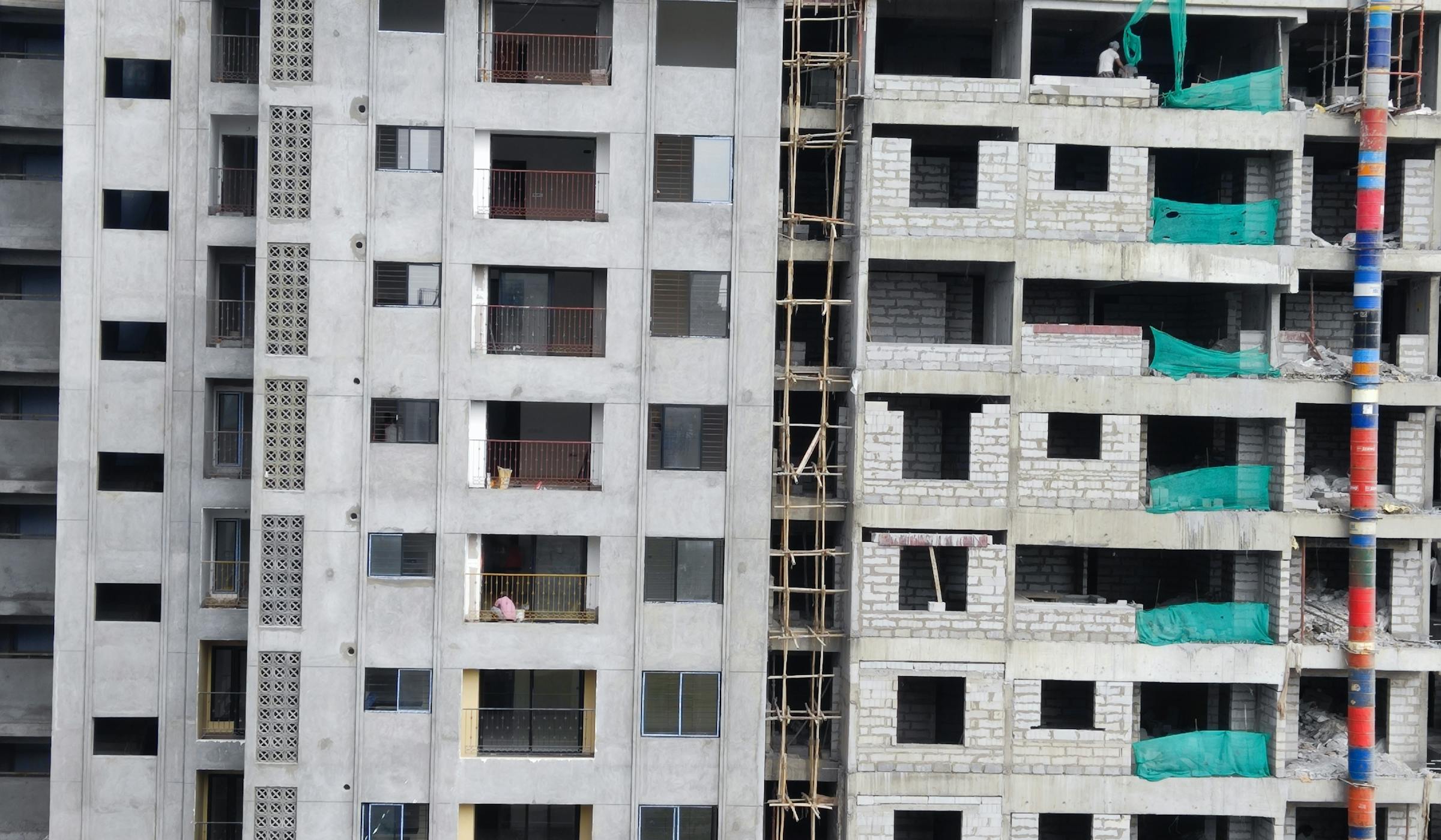 Residential tower under systematic construction in Chennai, scaffolding and workers visible